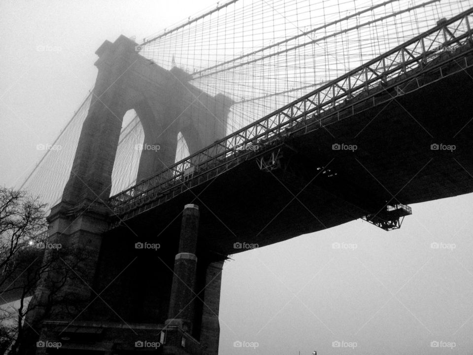 Low angle view of Brooklyn bridge in fog