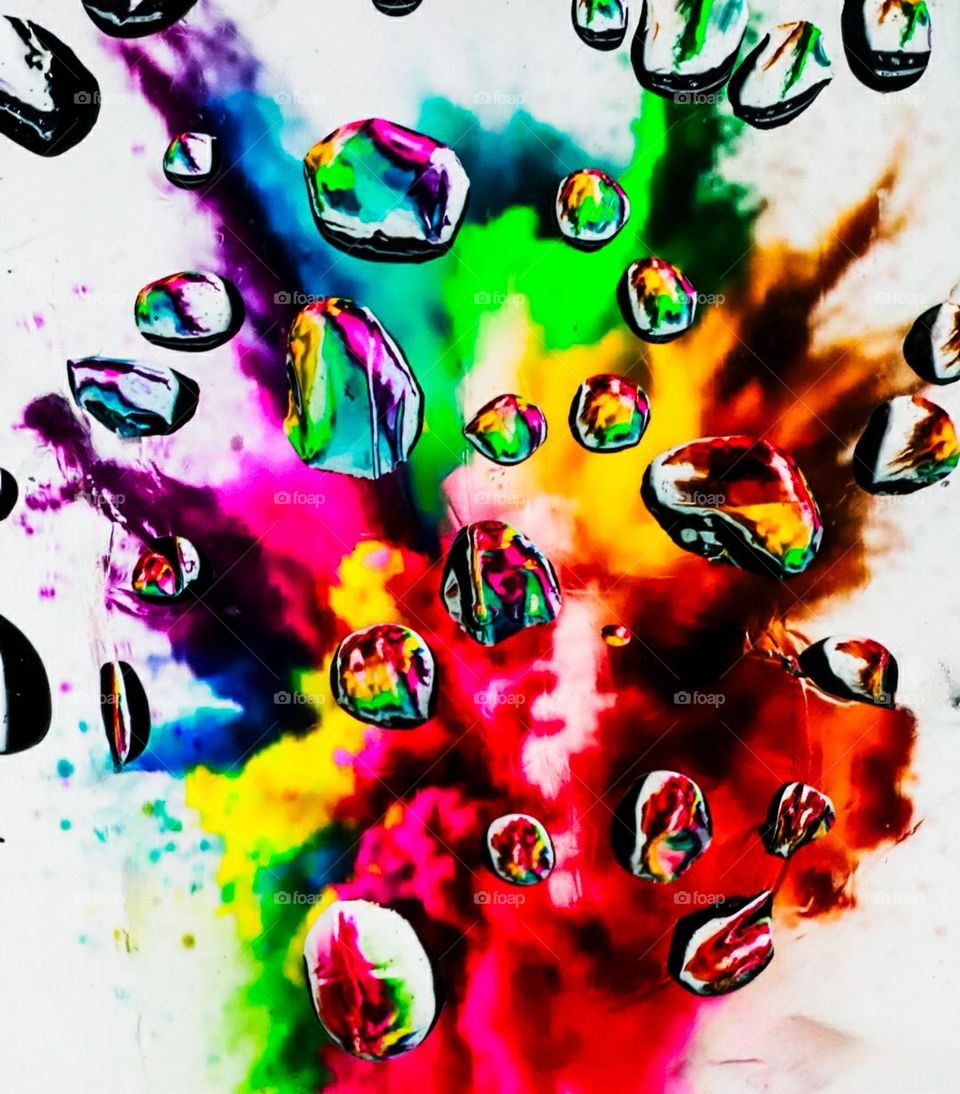This picture represents some splashes of water in which many colors are reflected.