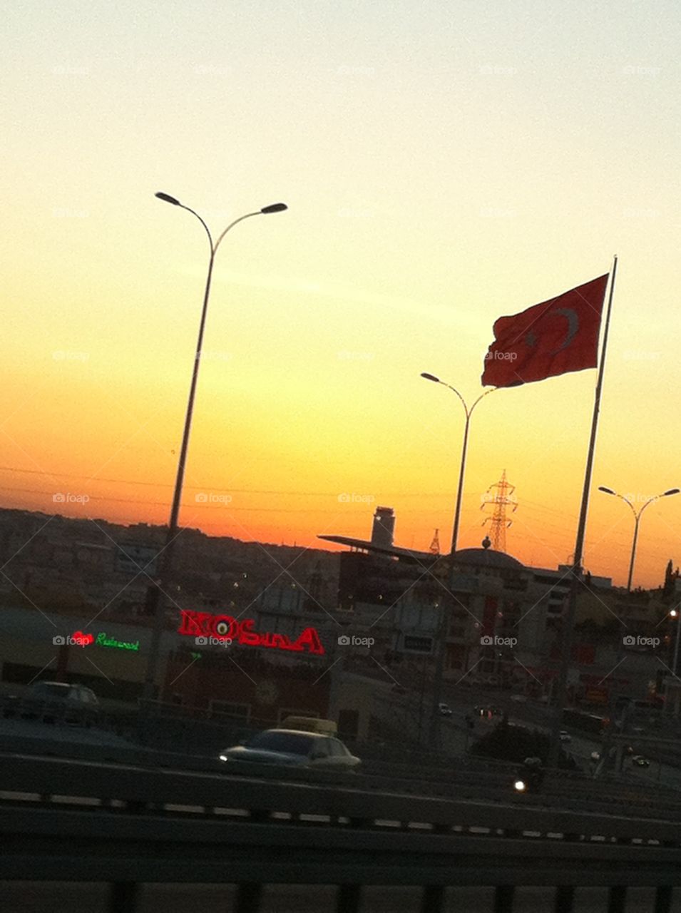 Sunset over Istanbul Traffic . The Turkish flag and the Istanbul sunset during evening traffic.  