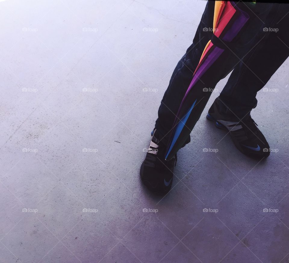 Man legs and an closed colorful umbrella 