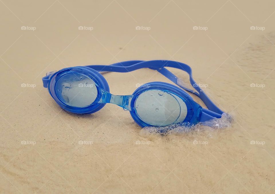 swimming goggles on the beach sand 🏖️