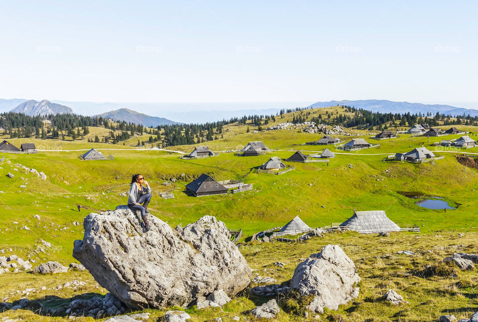 Happy hiker enjoying the beautiful view of village on mountain on a sunny day