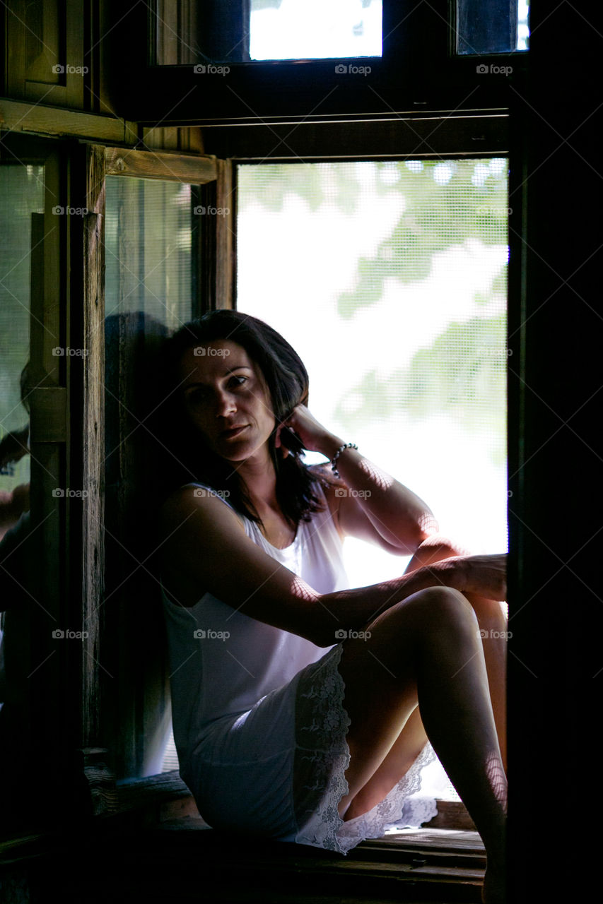Woman sitting on window sill