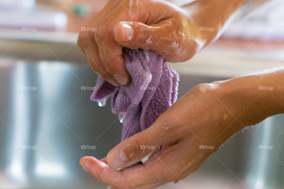 Woman washing rag in kitchen