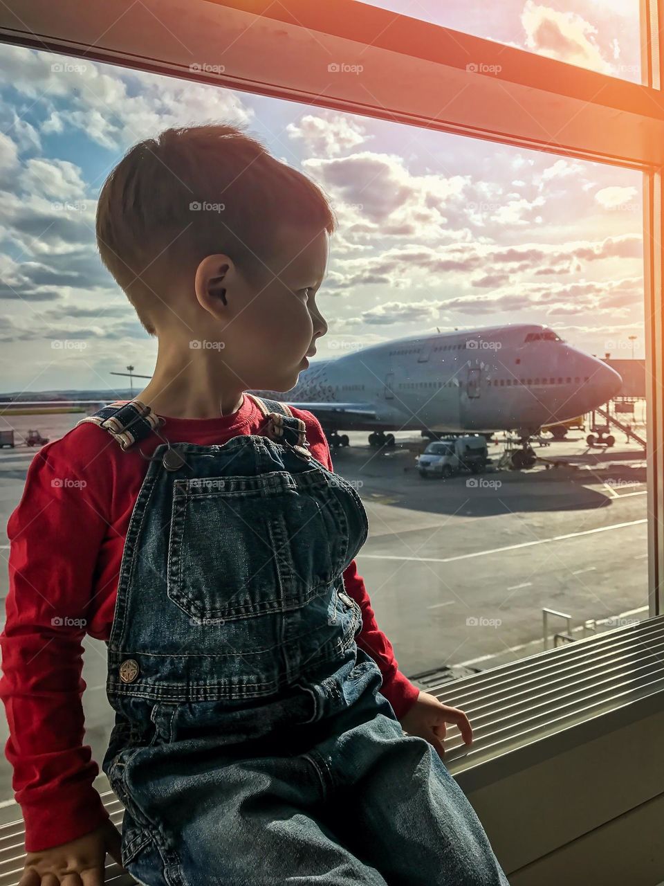 Boy looking at the window in the airport 
