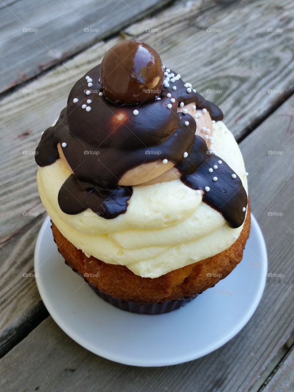 Salted caramel cupcake with chocolate fudge sauce, lopsided homemade view