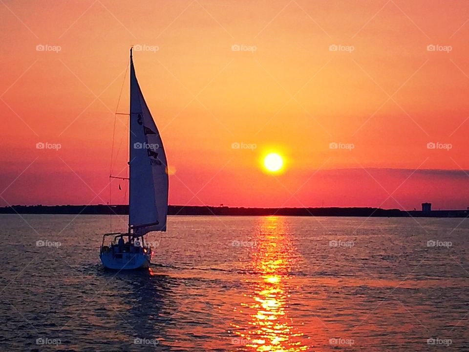 Sailboat in sea during sunset