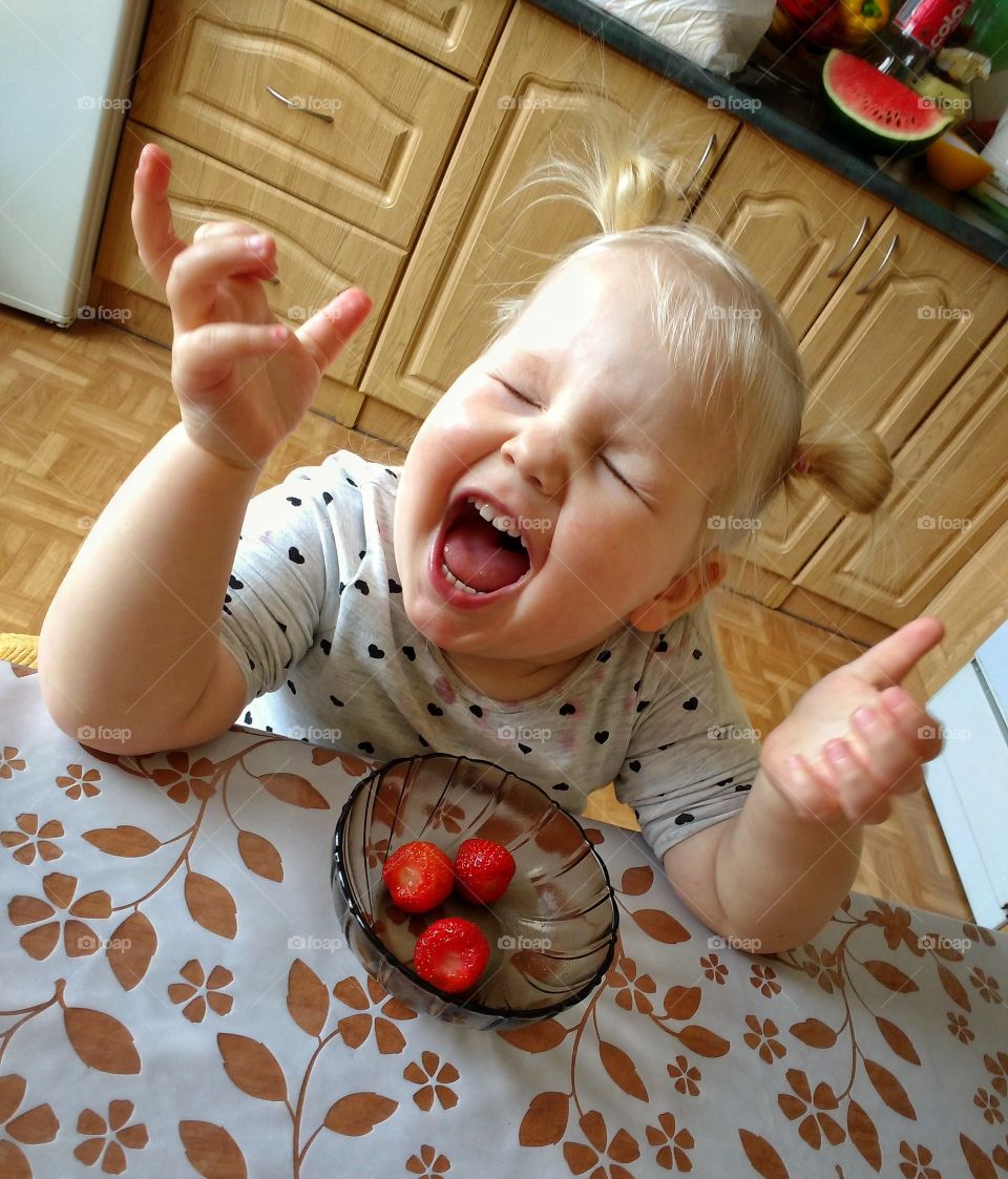 Happy girl eating strawberry