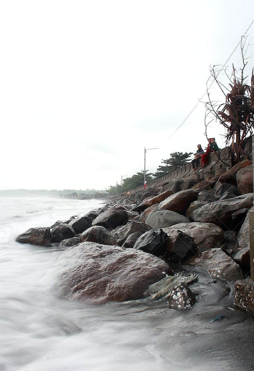 A corner side of the beach at the afternoon . Saliper ate named . The people's surround spend times for awaited the sunset.