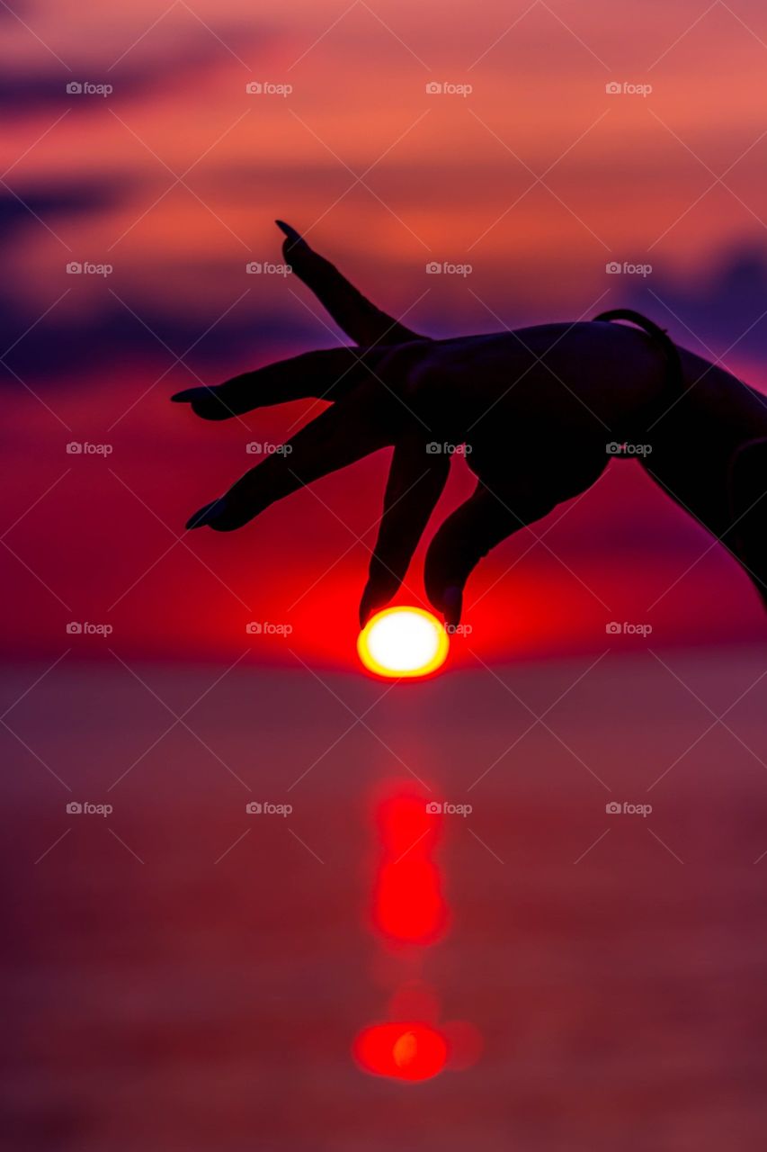 Silhouette of woman holding sun