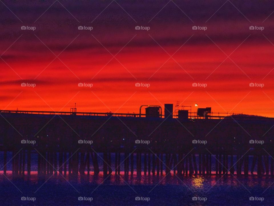Colorful dramatic sunset with silhouette of a bridge