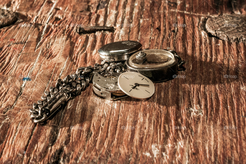 Dismounted retro watch lying on the wooden table.