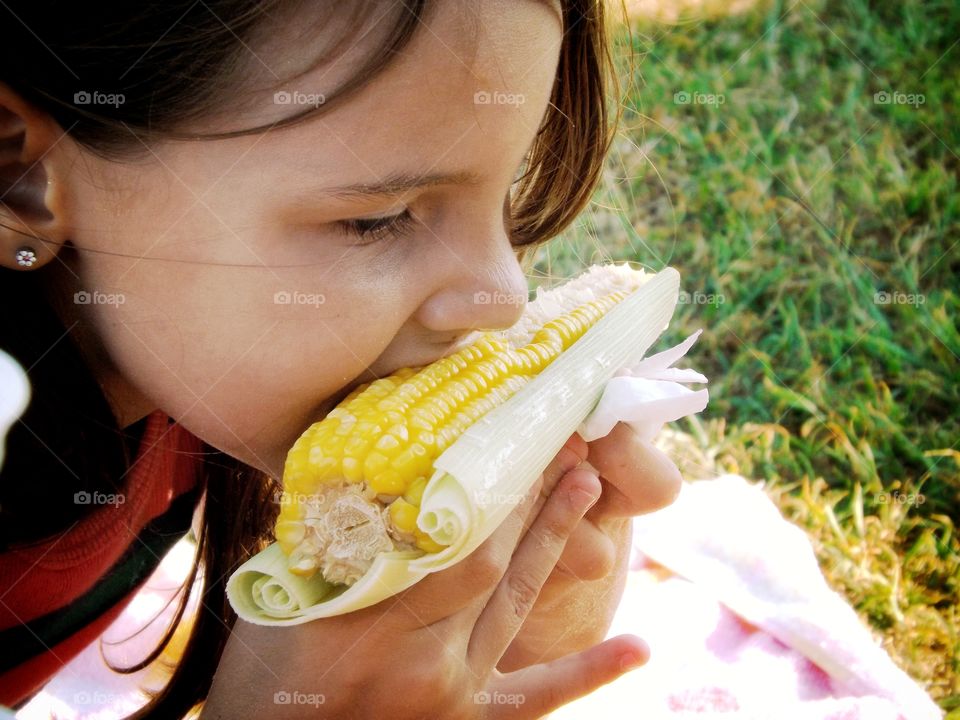 comendo milho na praia