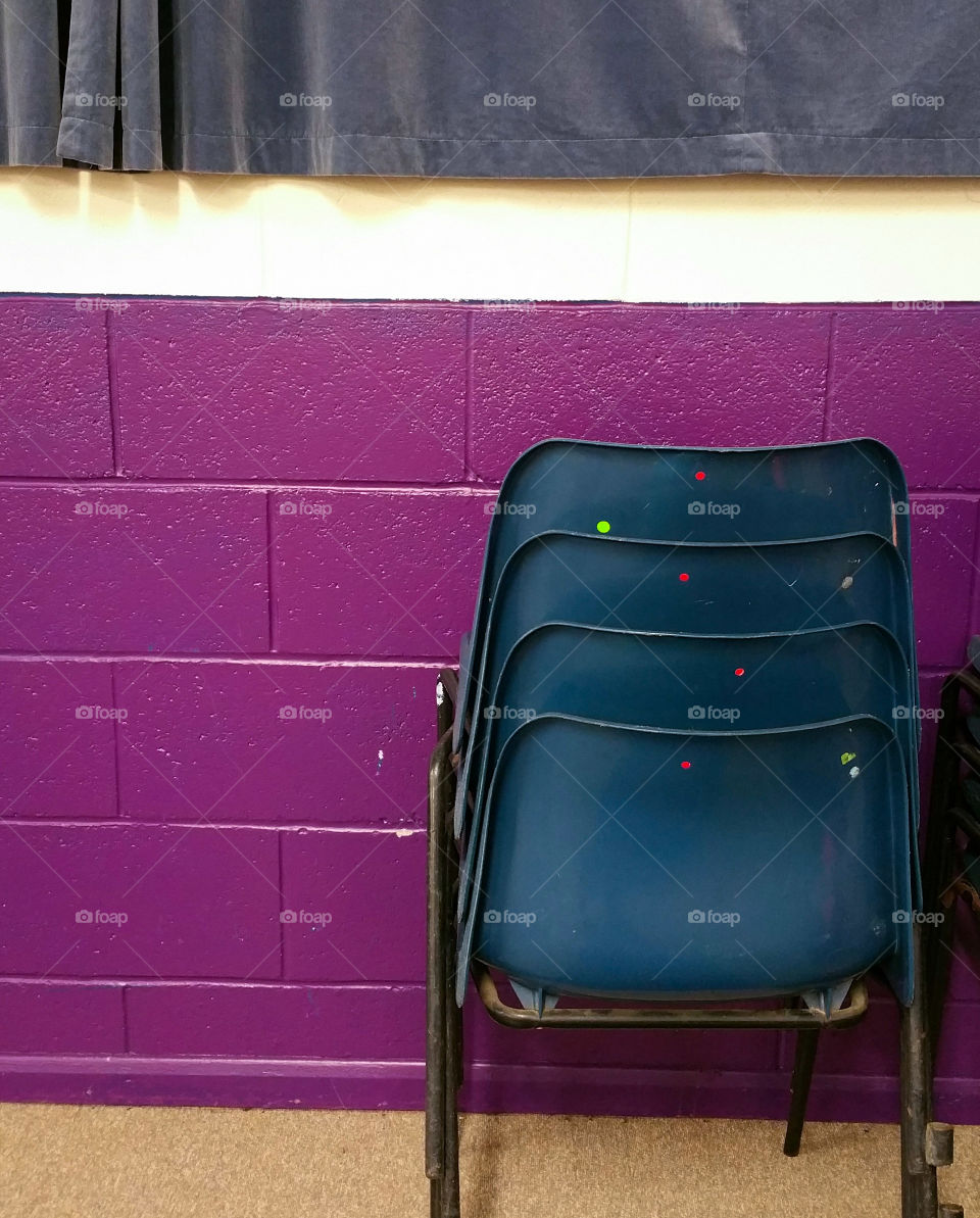 Stack of chairs in a purple room