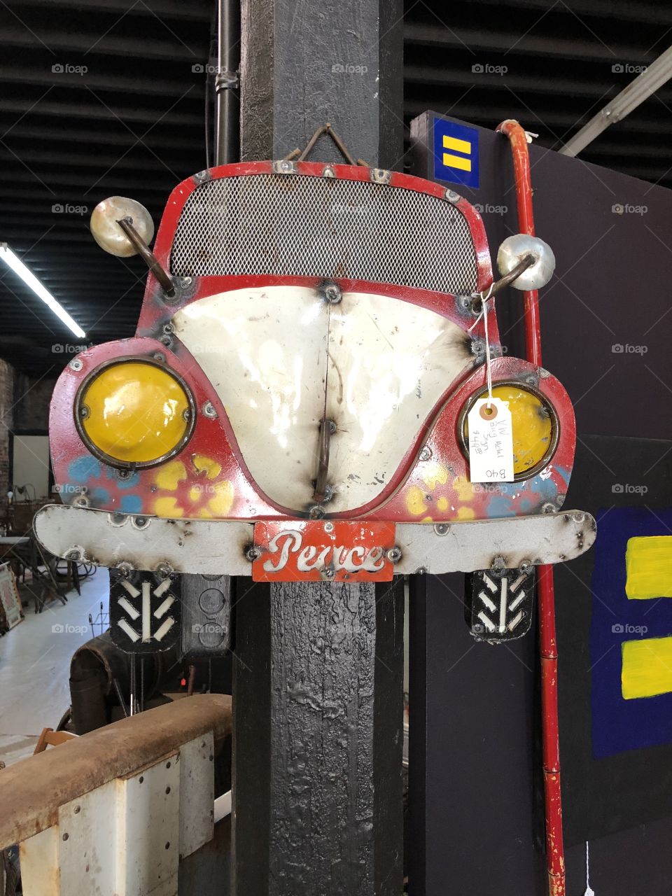 A Volkswagen metal  car in a shop that displays replica of car in a cutesy way. 