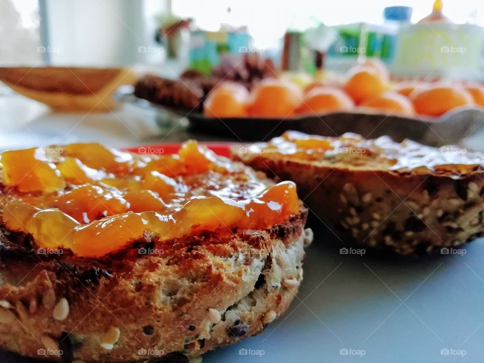 Homemade peach jam spread on whole grain dark rye bread