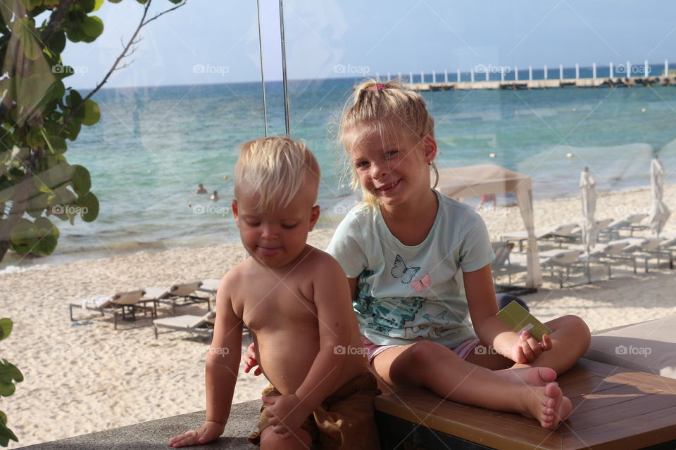 Two cute siblings having fun at the beach 