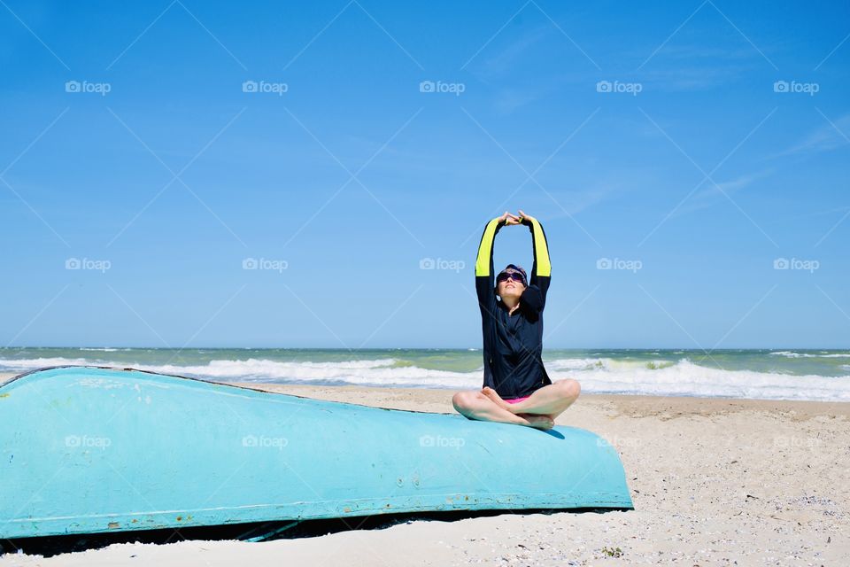 Woman doing yoga at sea beach 