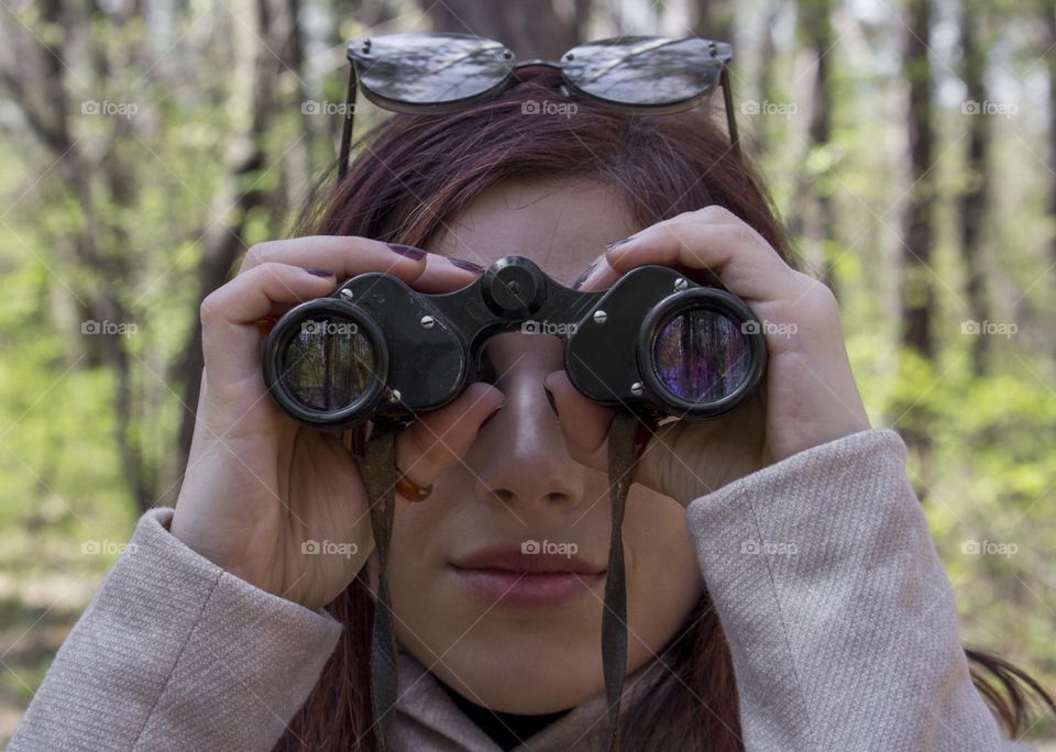 Close up of woman holds binoculars