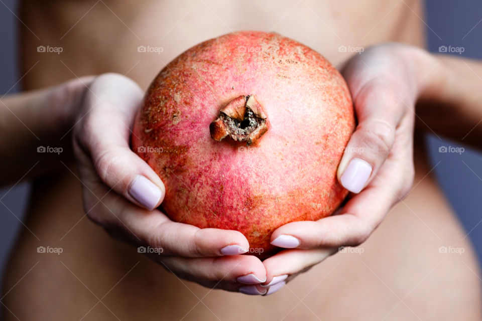 Woman hands holding fresh pomegranate 