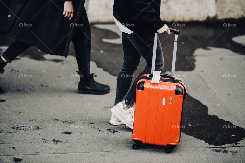 Millennial tourists travel with a red suitcase