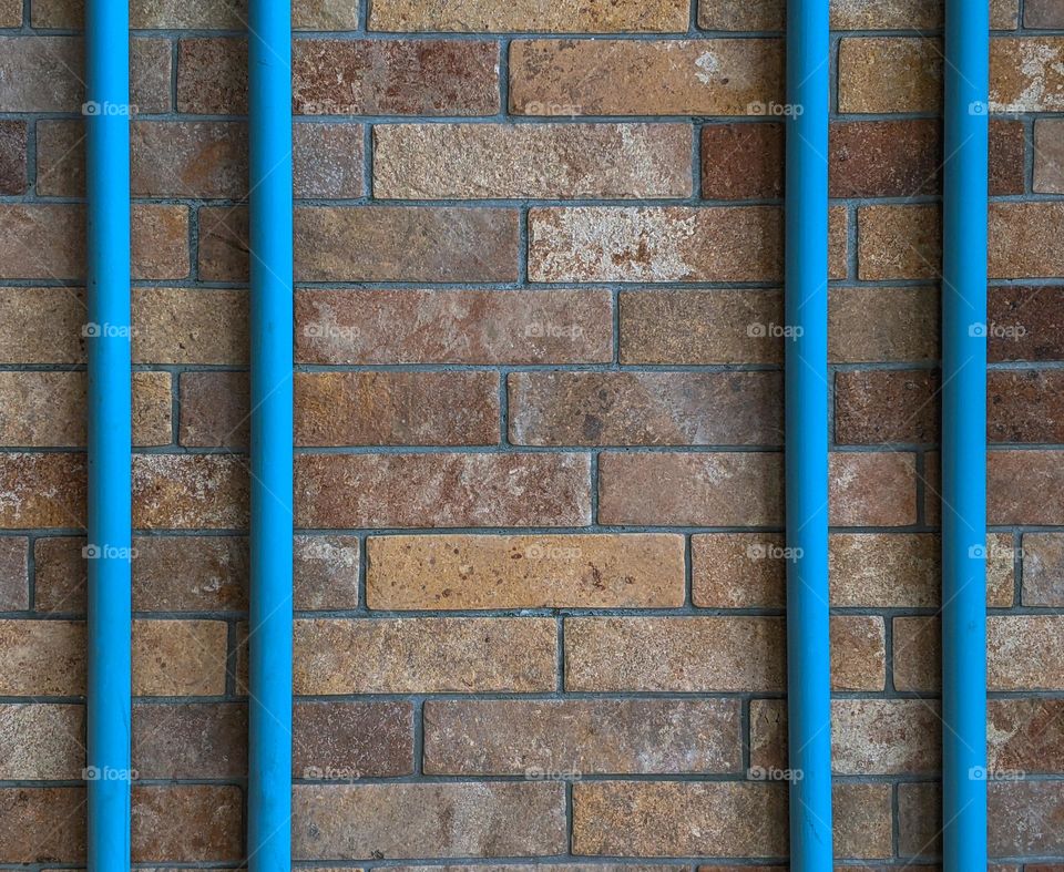 blue pipes on a brick wall