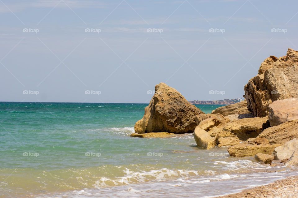 Sea Rocks on beach with blue sea