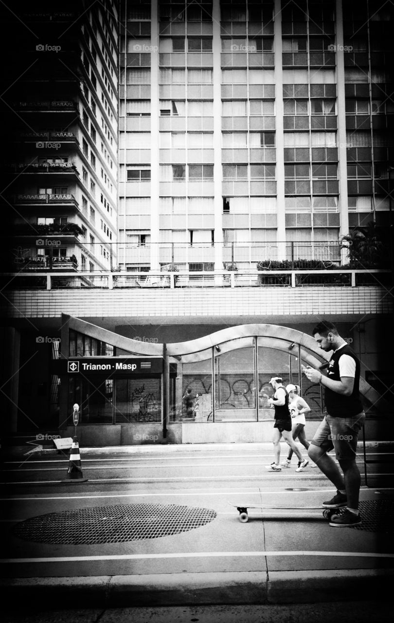 Skater looking mobile phone at Paulista avenue in São Paulo 