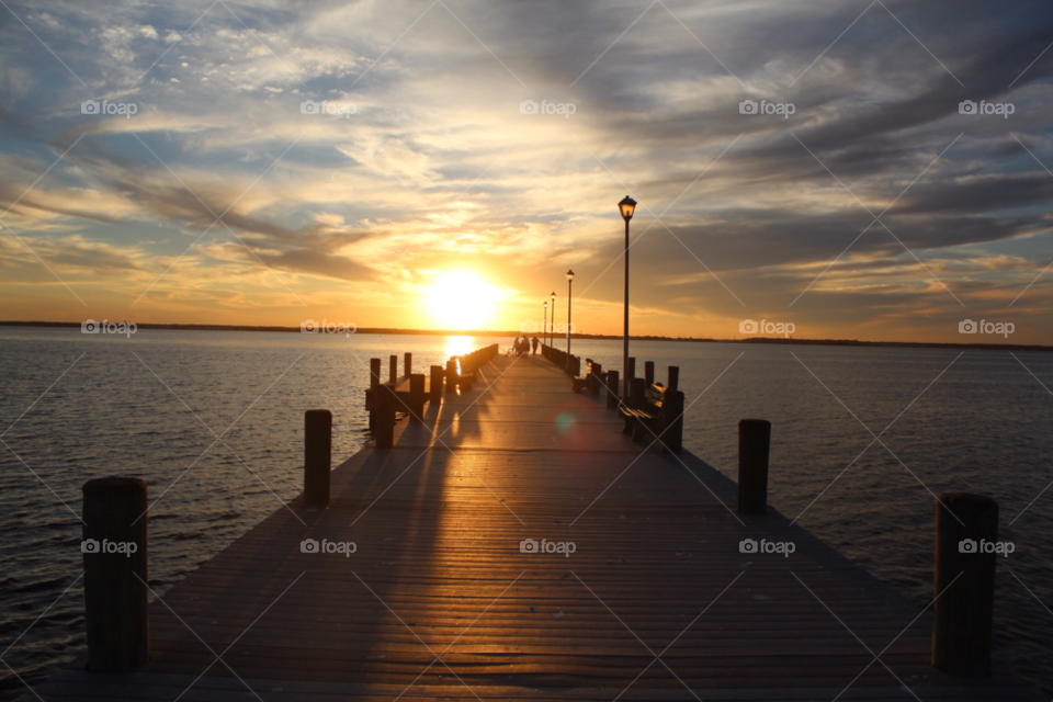 Scenic view of pier over sea at sunset