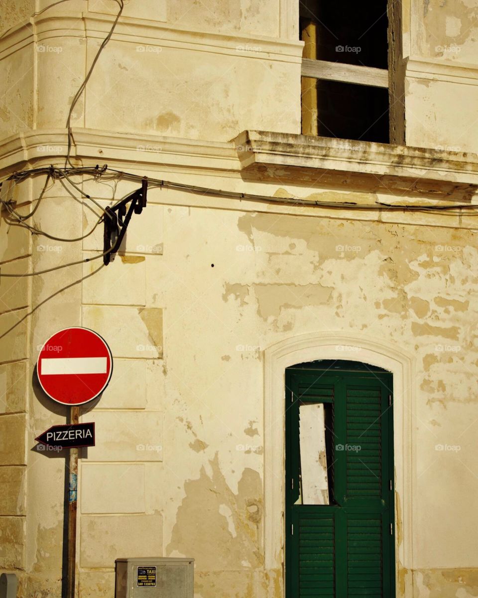 Traditional Italian streets, with one-way sign pointing to a pizzeria.