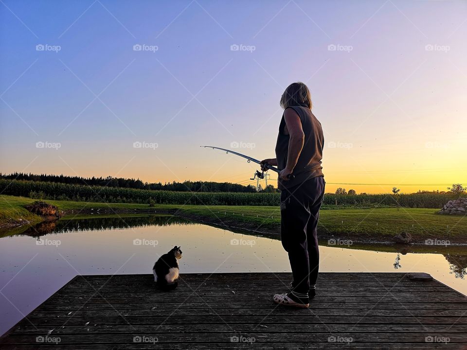 Senior woman and cat waiting fish