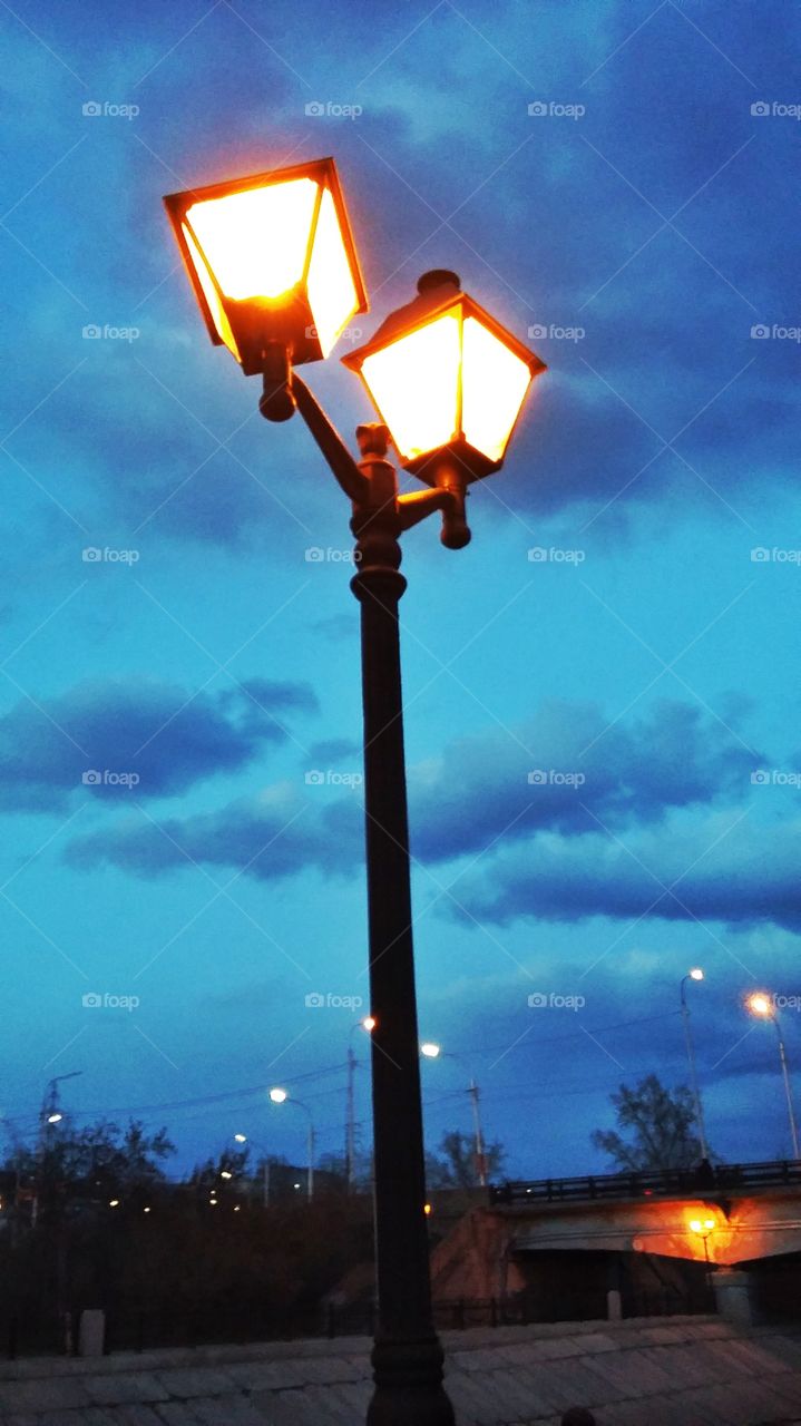 городской горящий фонарь на наьережной на фоне ночного неба