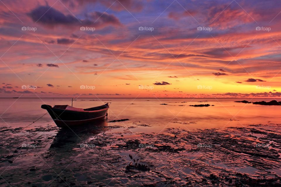 Single boat in dusk. Sunset at Batakan Beach, Souh Kalimantan, Indonesia.