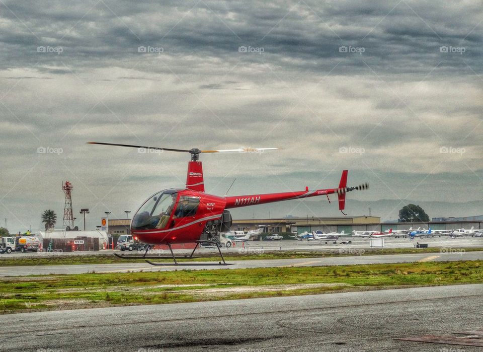 Helicopter Hovering Over Runway. Robinson R-22 Helicopter Preparing For Takeoff