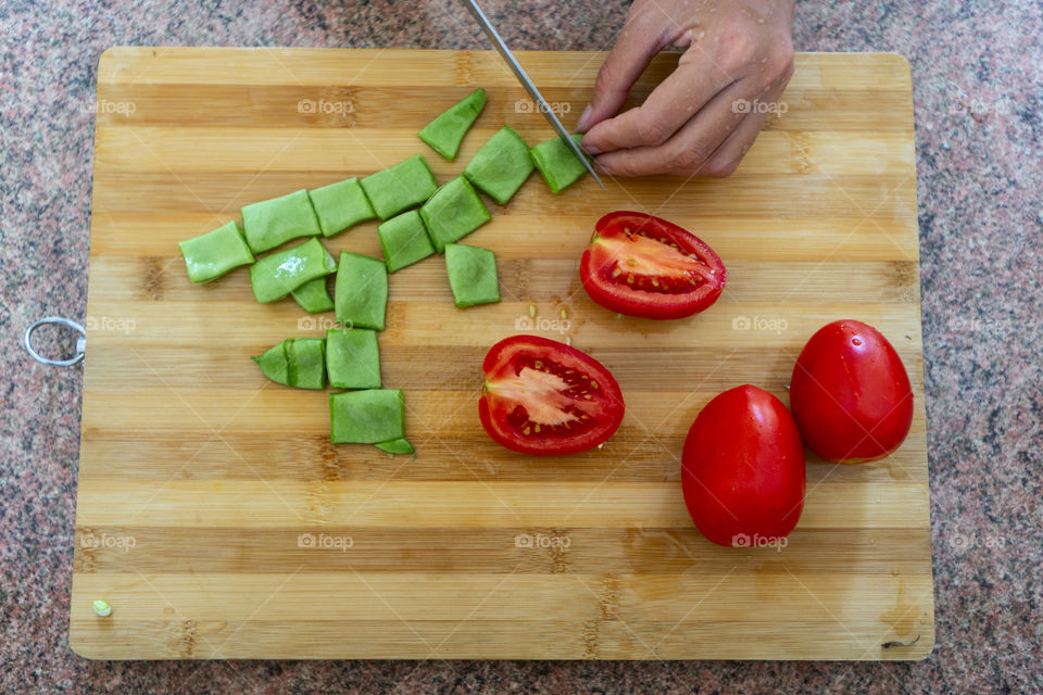 Green cubes of pea pods on a wooden board