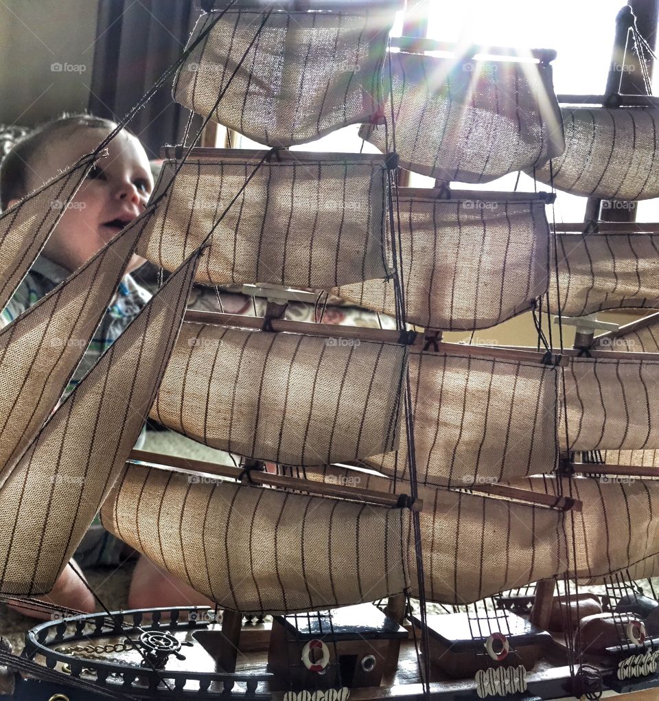 Child playing near toy sailboat