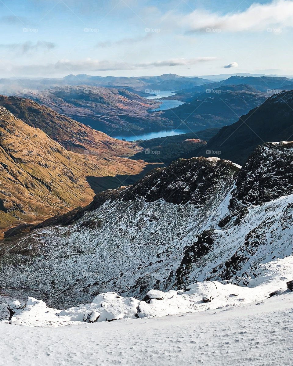 Beautiful view of the scenic Scottish Highlands with lochs and mountains. A lovely sunny day to explore, hike, travel and enjoy new adventures in Scotland.