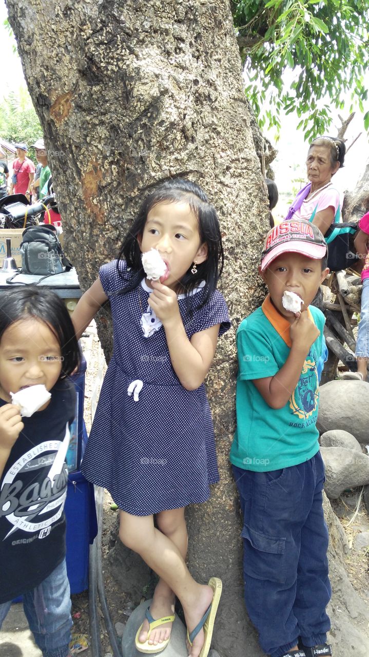children licking popsicle