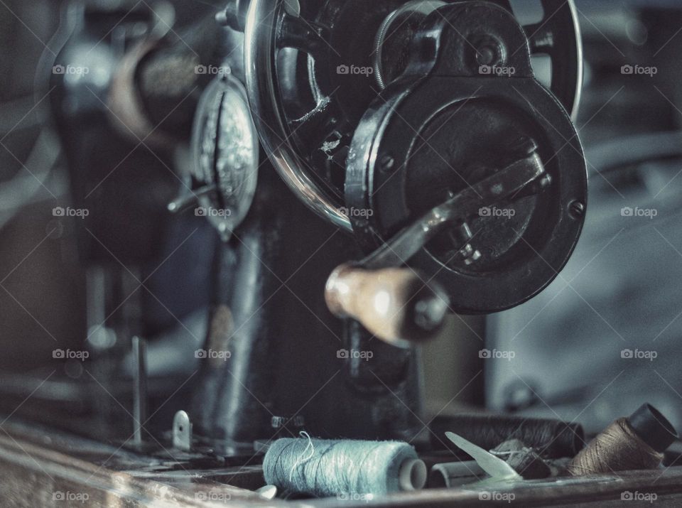An old mechanical sewing machine with manual drive.
