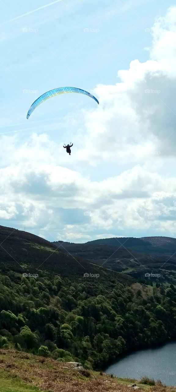 paragliding over mountains, forests and lake