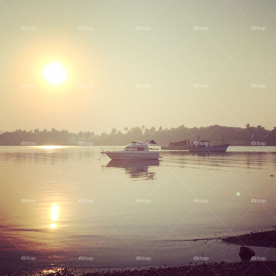 Boats moored at idyllic lake at sunset