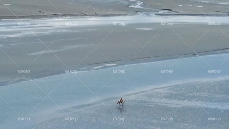 horseman in the sea. the horseman passing the distance between mont saint michel and jersey island in France.