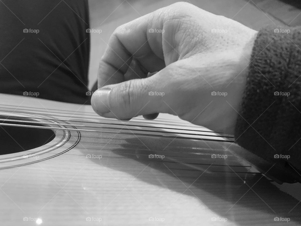 Playing guitar B&W touching strings