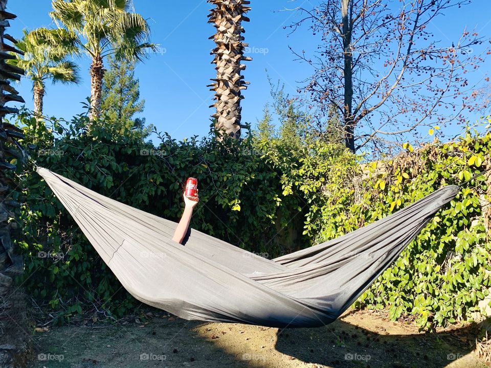 Laying in a hammock with a can of Coca Cola 