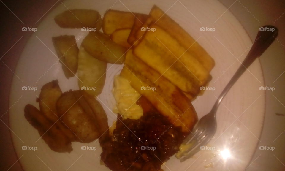 a nice plantain, fry dumplings and stew chicken dish