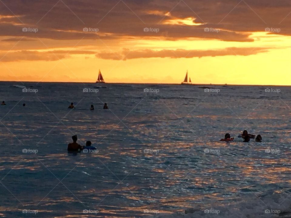 Tourists swimming in sea during dusk