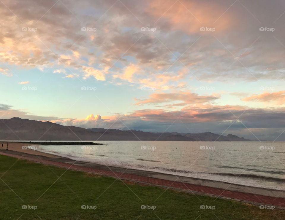 Serene sea landscape with mountain backdrop on s cloudy evening during the golden hour 