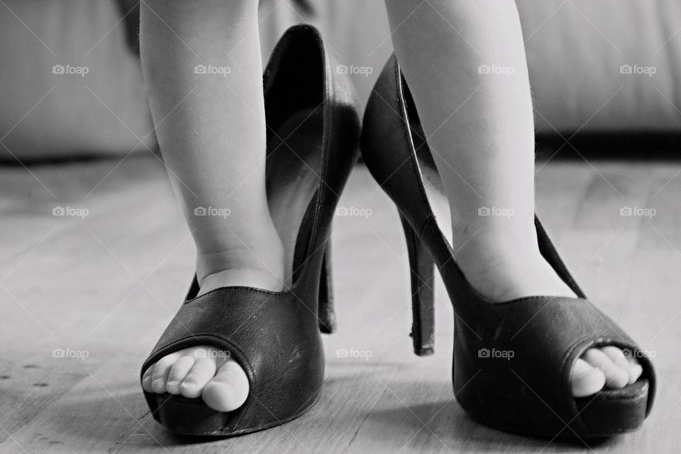Low section of child wearing high heels