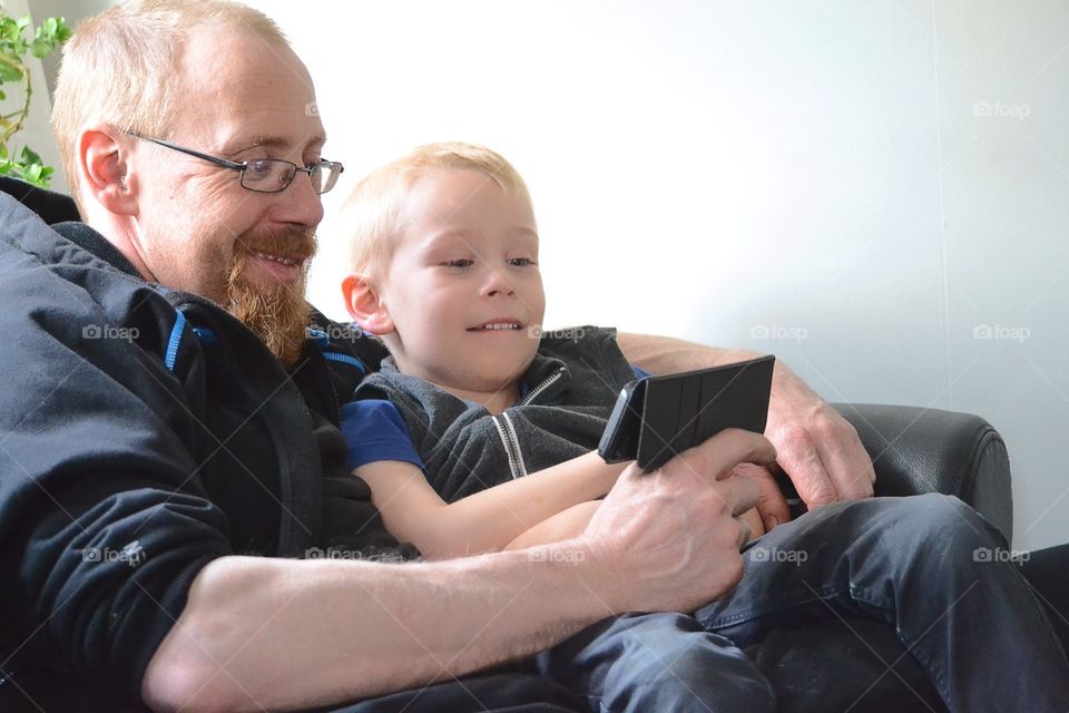 Father and son using a mobile phone