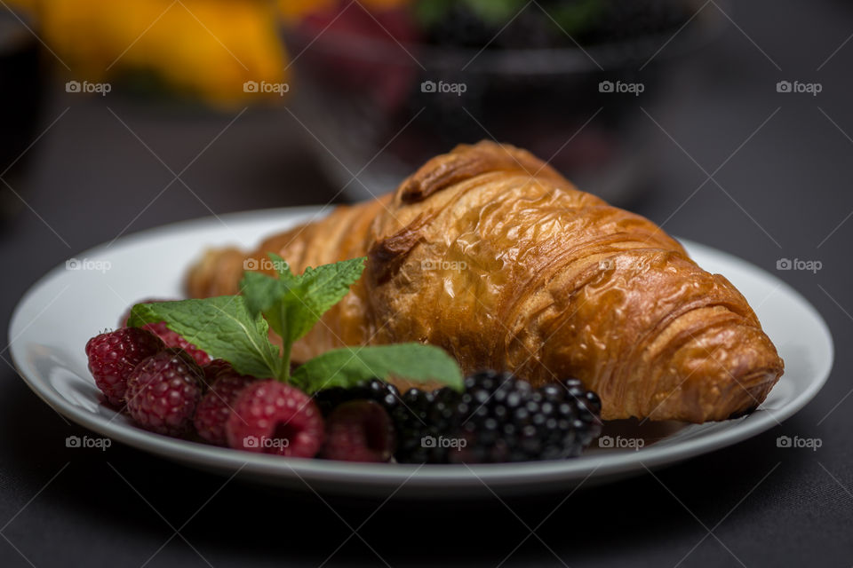 Croissant with berry fruits on plate